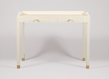 French mid-century writing desk in solid wood and plywood, pale grey-green lacquer finish, sycamore veneer drawer interiors, integrated cable management and unlacquered polished brass sabots